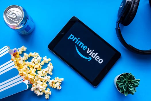Calgary, Alberta. Canada. June 1 2020. An iPad with the Prime Video logo on the screen on a blue background with popcorn and headphones