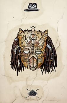 Collage on a wall in Paris (France). In the sixth arrondissement. African mask, Indian head, feline head.