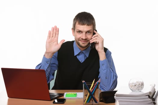 The man sitting at the table and talking on the phone raised his hand in greeting