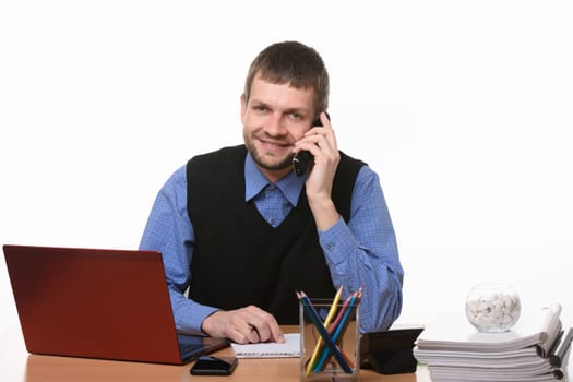 Entrepreneur talks on the phone at the desk on a white background