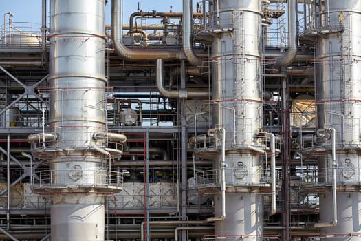 Close-up of pipelines and destillation tanks of an oil-refinery plant.