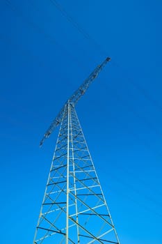 Power pole on a field under a cloudless blue sky