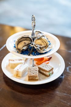 Welcome cocktail Canapes dish, Fresh Oyster and smoked salmon seafood dish. Appetizer dish before groumet brunch buffet international cuisine.