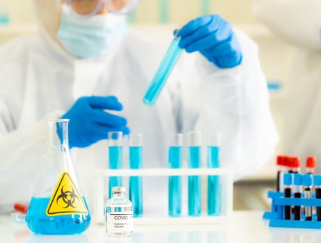 Coronavirus COVID-19 Vaccine with background of Scientist working and holding rest tube to examine research and develop vaccine for ncov-2019 world pandemic. Medical technology and healthcare concept.