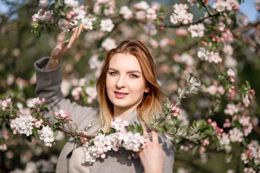Young girl with her hair in a blooming apple orchard, ecology, care