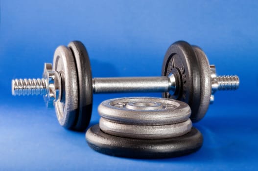 Barbell with free weights on a blue backround