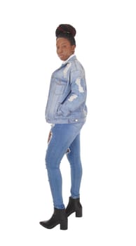 A young African American woman standing in ripped jeans and a.jacket and white top, isolated for white background.
