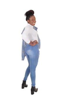 A tall young African American woman standing in jeans, .from the back, jacket over her shoulder, isolated for white background.