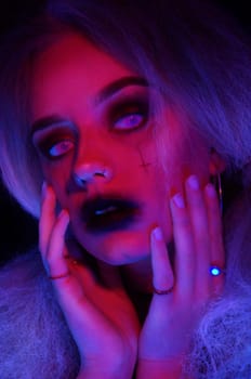 blond woman in blacklight with makeup