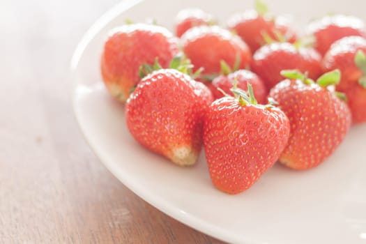 Fresh strawberries on white plate, stock photo