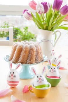 Colourfully decorated Easter eggs and fresh sand cake Gugelhupf