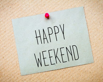 Recycled paper note pinned on cork board.Happy Weekend Message. Concept Image