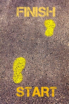 Yellow footsteps on sidewalk from Start to Finish message. Conceptual image