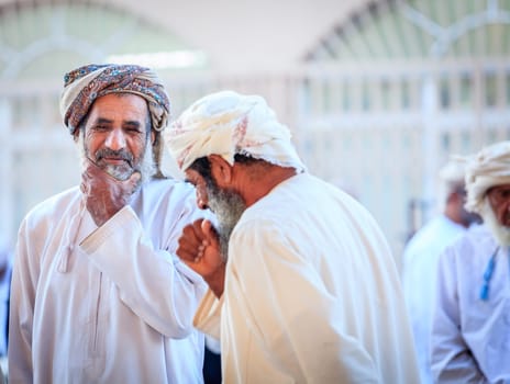 Nizwa, Oman, December 2, 2016: Local men shopping at the Friday goat market in Nizwa, Oman