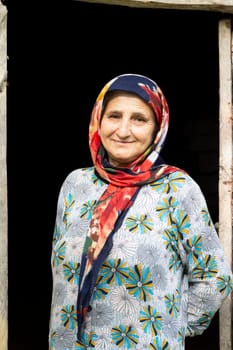Portrait of a Muslim woman in traditional cloth at dark doorway