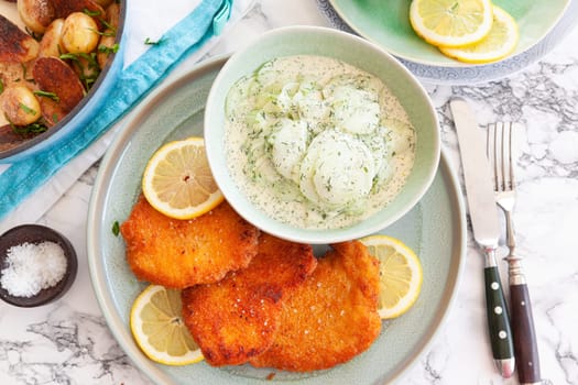 Breaded chicken schnitzel with baked potatoes and cucumber salad
