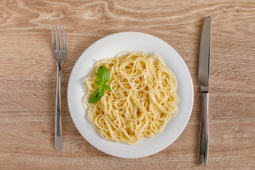 Spaghetti on a plate top view on a wooden background