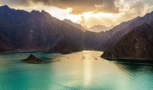 Scenic view of Hatta Lake and Hajar Mountains in the Emirate of Dubai, UAE at sunset