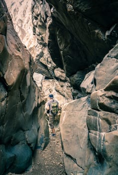 A man is hiking through a wadi in Hajar Mountains near Hatta, UAE