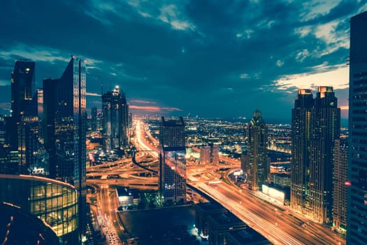 Bird's eye view of Dubai skyline and rush hour traffic in downtown at night