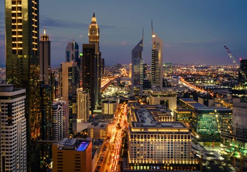 Bird's eye view of Dubai Financial District skyline and rush hour traffic after sunset