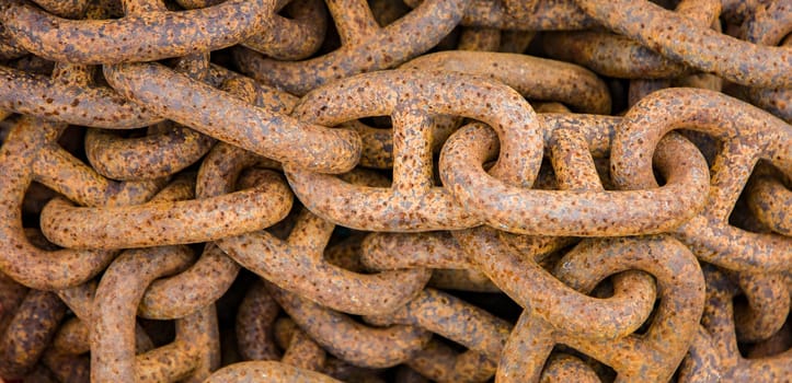 Close up of old ship chain rusting in port