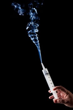 Man holding hyperdermic needle which is shooting smoke