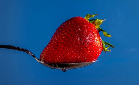 Strawberry on a spoon, washed and ready to eat