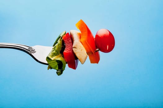 Salad on a fork on a blue background
