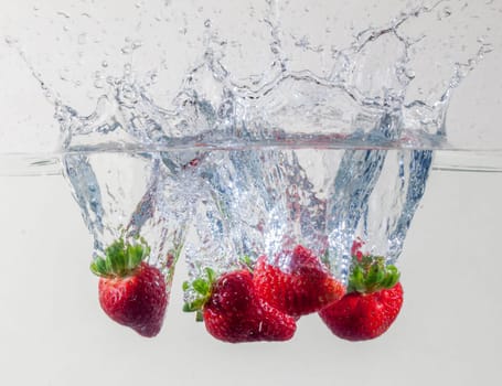 Ripe Strawberries Dropping Into Water