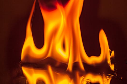Open flame with reflection on black glass