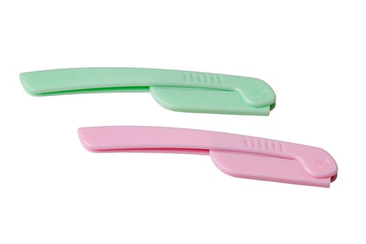 Cosmetic tools. Close-up of a pink and a green eyebrow razor for shaving body hair isolated on a white background. Beauty concept. Macro.