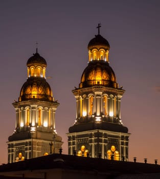 Illuminated towers of Iglesia Santo Domingo in Cuenca, Ecuador, at night