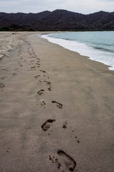 Foot steps in the sand on a beach in Ecuador