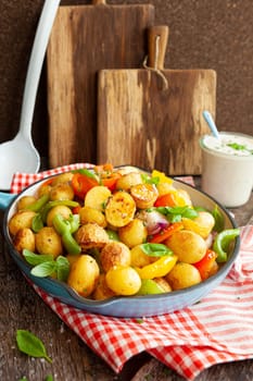 Baked pototoes with bell peppers in a cast iron skillet