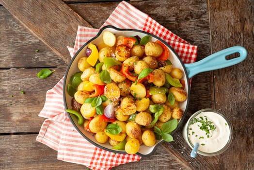 Baked pototoes with bell peppers in a cast iron skillet
