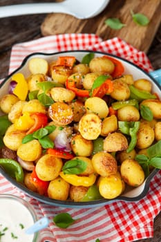 Baked pototoes with bell peppers in a cast iron skillet