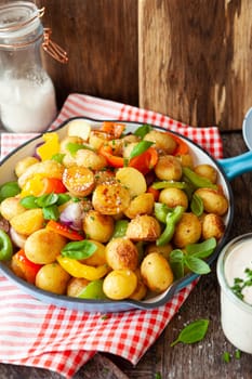 Baked pototoes with bell peppers in a cast iron skillet
