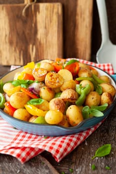 Baked pototoes with bell peppers in a cast iron skillet