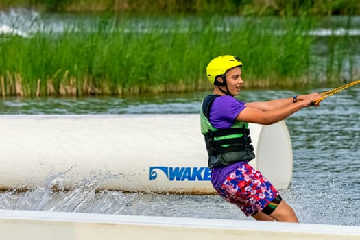 Teenager wakeboarding on a lake - Brwinow, Masovia, Poland