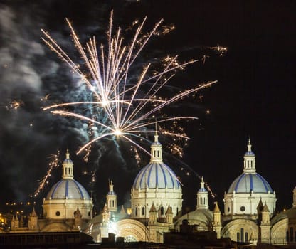 Fireworks over the domes of the New Cathedral in Cuenca, Ecuador. These are the famous view that are usually found on all travel brochures for the city.