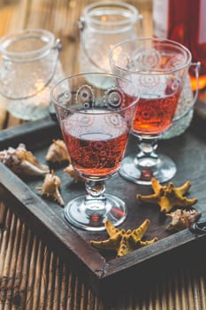 Two vintage glasses of red wine with bottle and lantern on wooden background