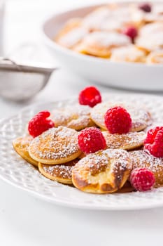 Poffertjes - small Dutch pancakes with fresh raspberries. Traditional Dutch cuisine.