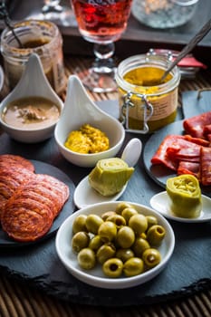 Assortment of tapas and antipasti on black background. Charcuterie boards of assorted appetizers.