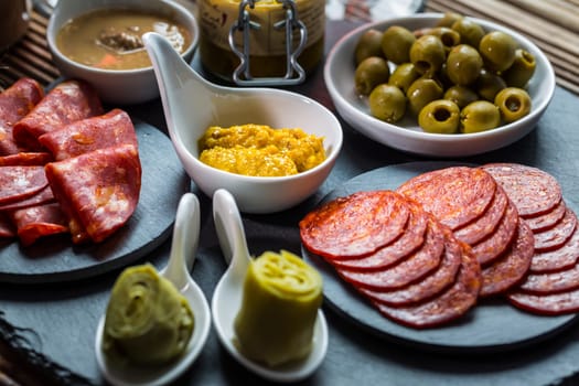 Assortment of tapas and antipasti on black background. Charcuterie boards of assorted appetizers.