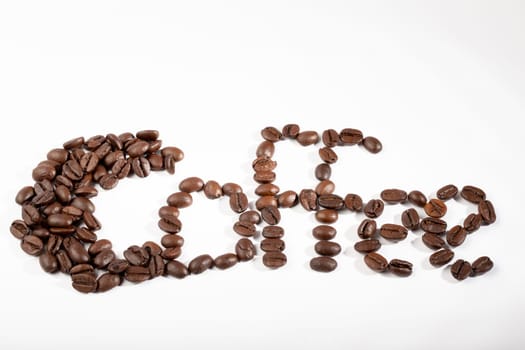 word coffee written with coffee beans on a white background