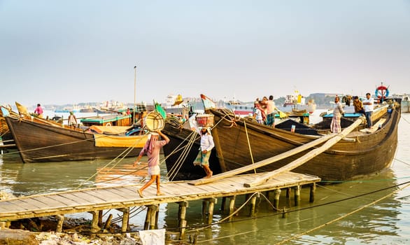 Chittagong, Bangladesh, December 22, 2017: Manual offloading of salt from a boat at the Karnaphuli River port in Chittagong, Bangladesh