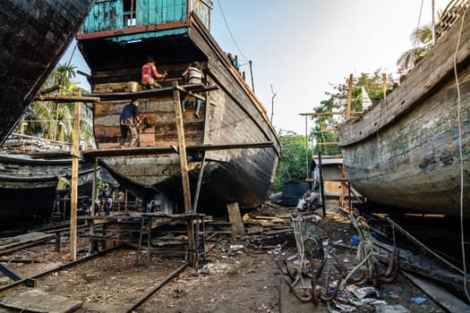 Chittagong, Bangladesh, December 22, 2017: Traditional fishing boats are being built at a shipyard by the Karnaphuli River near Chittagong, Bangladesh