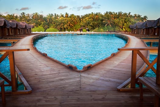 Maldives, bridge by the water villas, view to the island