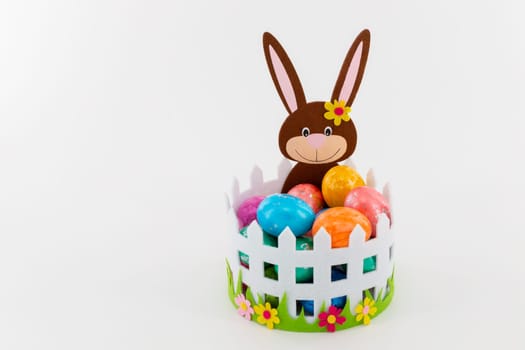 Some Colorful Easter eggs in a basket with an Easter bunny